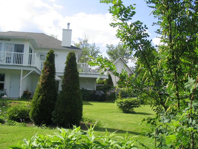 Cours extérieur avec jardin et terrasses de notre auberge «Les Studios du Vacancier» à St-Donat dans Lanaudière